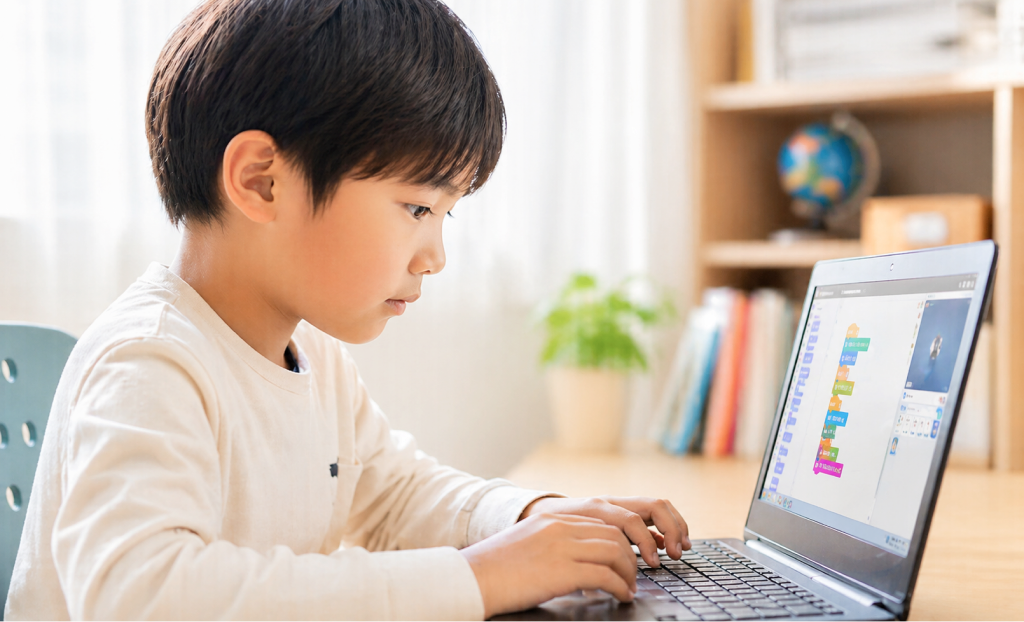 ノートパソコンでプログラミングに取り組む男の子