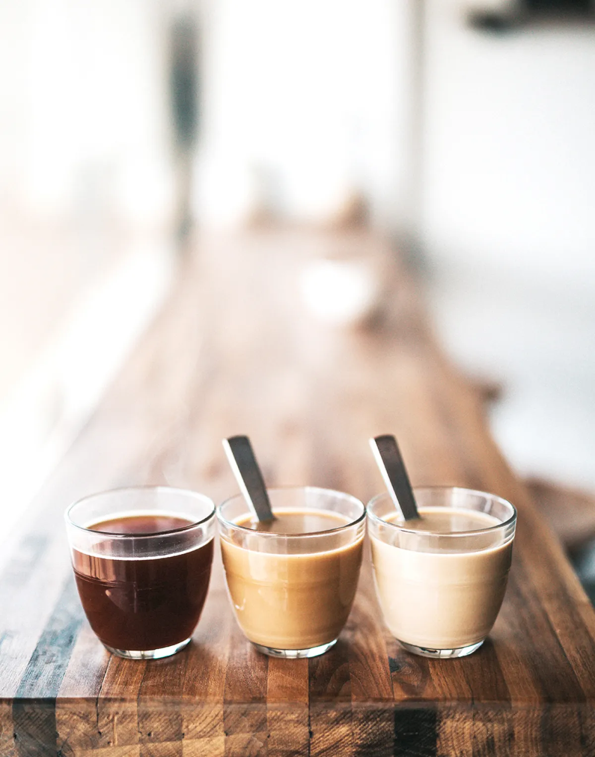 コーヒーとカフェオレが並ぶ木のテーブルの様子